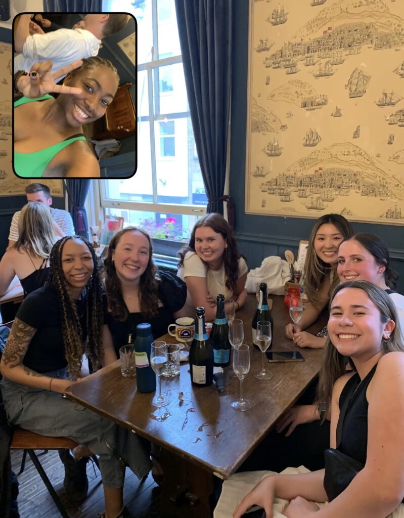 Team of young professionals sitting at a restaurant table, toasting with champagne.