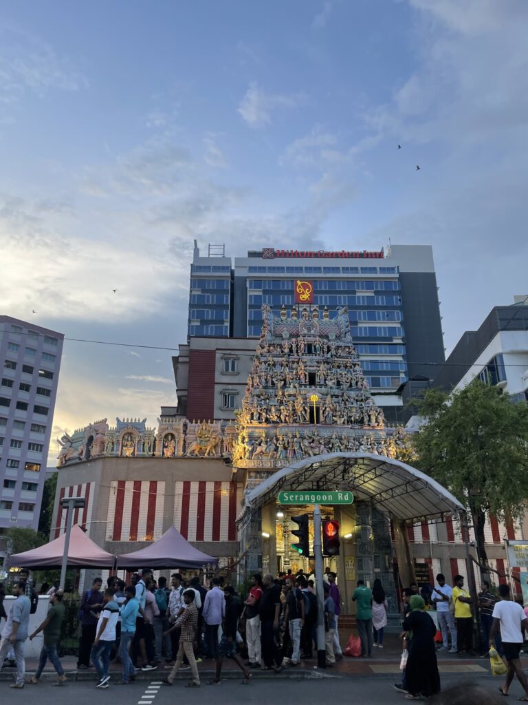 Bright market with large crowds, elaborate architecture, and a brightly lit skyline.