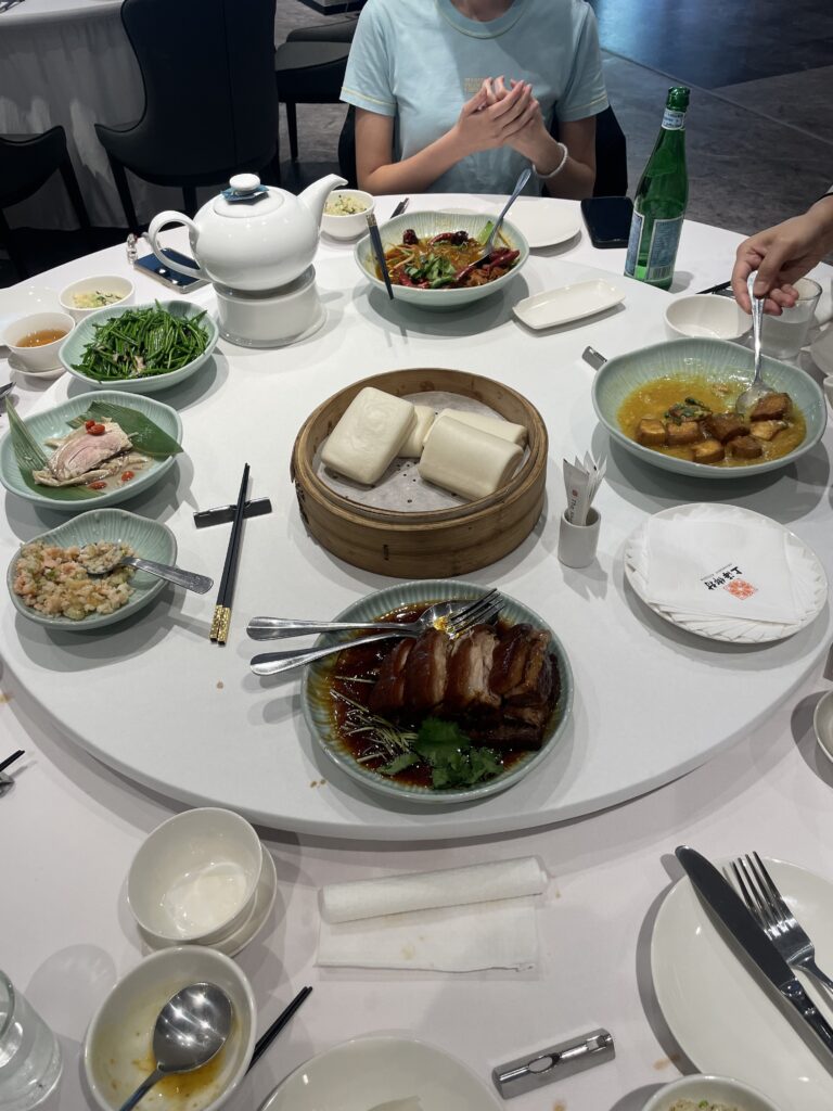 Round rotating table with various brightly colored Thai dishes and a tea pot.