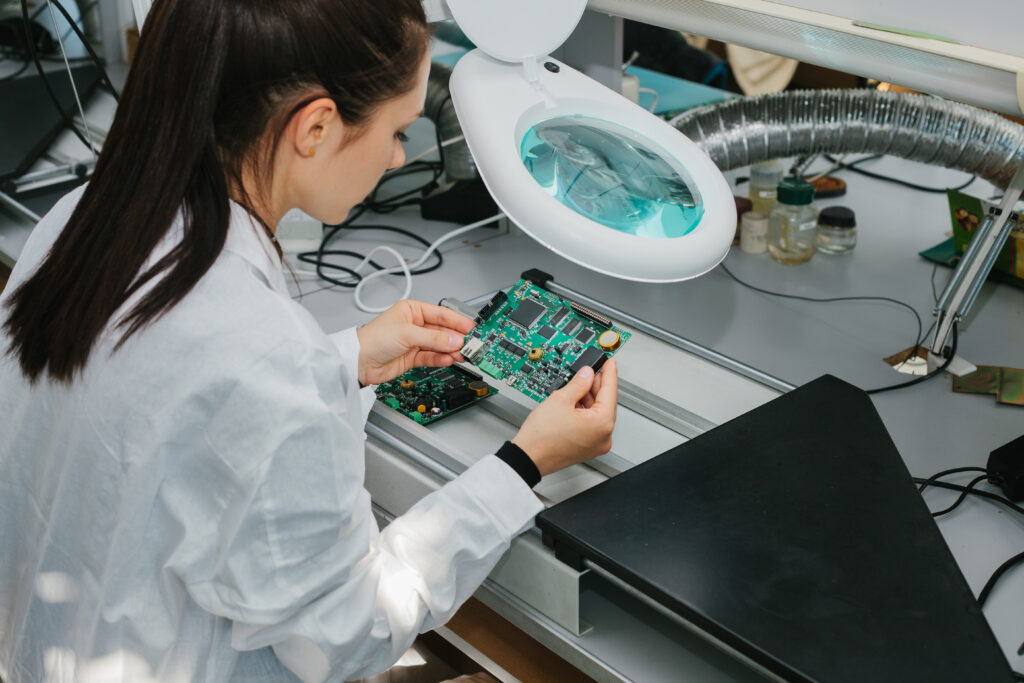 Female scientist in a lab analyzing a semiconductor chip.