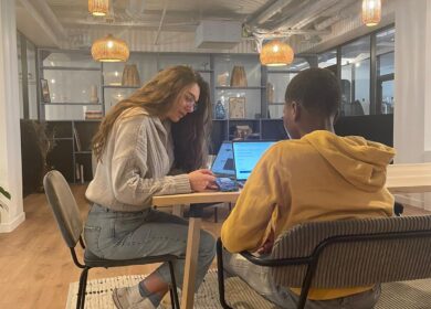 Two people sitting at a desk in an office.