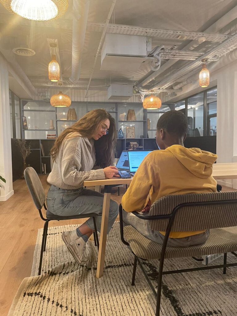 Two people sitting at a desk in an office.